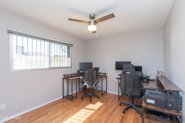 office featuring a ceiling fan, light wood-style floors, and baseboards