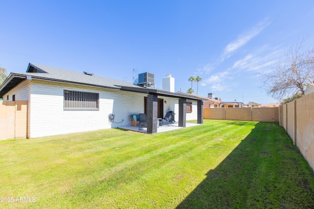 rear view of property featuring a fenced backyard, a yard, a patio area, and cooling unit