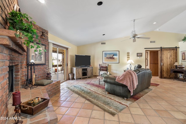 living room featuring ceiling fan, light tile floors, a barn door, a fireplace, and lofted ceiling