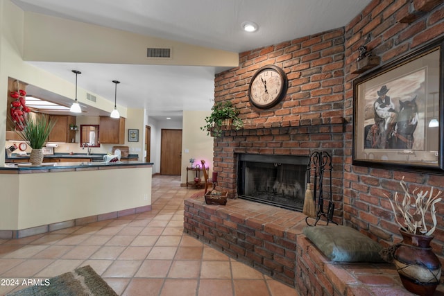 interior space featuring brick wall, a brick fireplace, and lofted ceiling