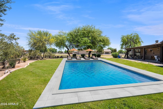 view of swimming pool featuring a patio and a yard