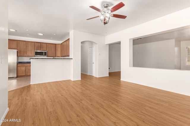 unfurnished living room featuring ceiling fan and light hardwood / wood-style flooring