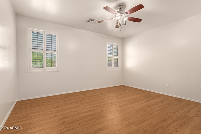 empty room with a healthy amount of sunlight, light hardwood / wood-style floors, and ceiling fan