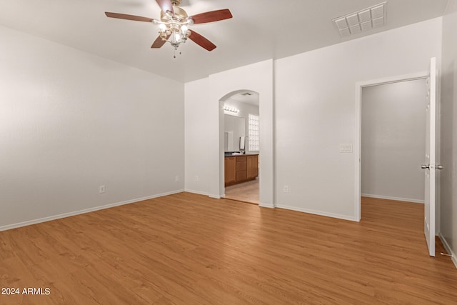 spare room with light wood-type flooring and ceiling fan