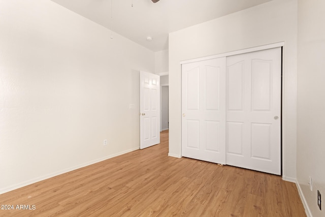 unfurnished bedroom with light wood-type flooring and a closet