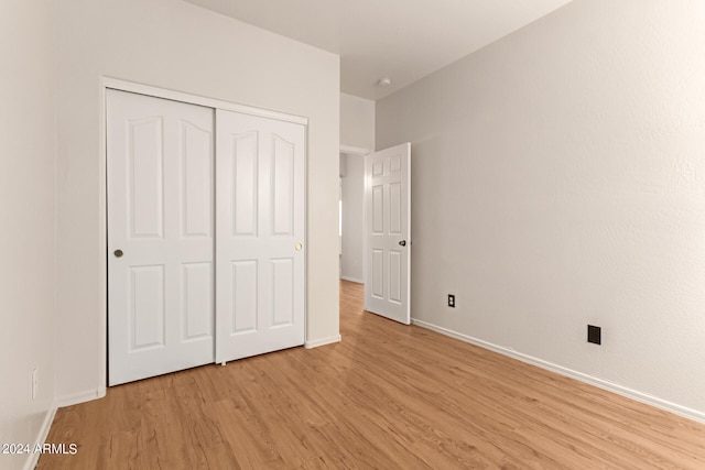 unfurnished bedroom with light hardwood / wood-style flooring and a closet