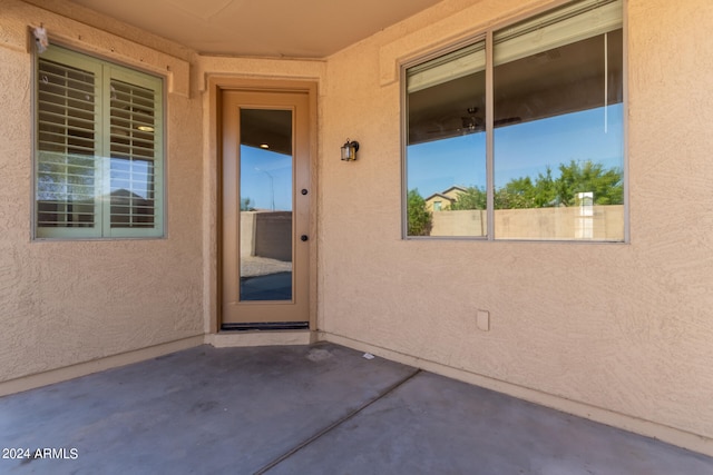 view of exterior entry with a patio area