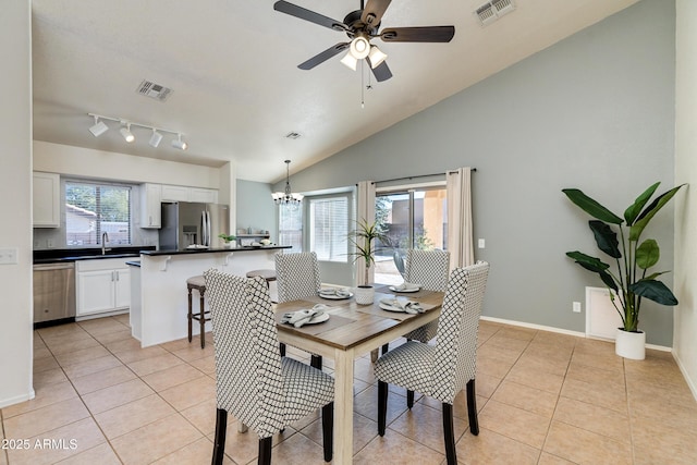 dining room with lofted ceiling, sink, ceiling fan with notable chandelier, and light tile patterned floors