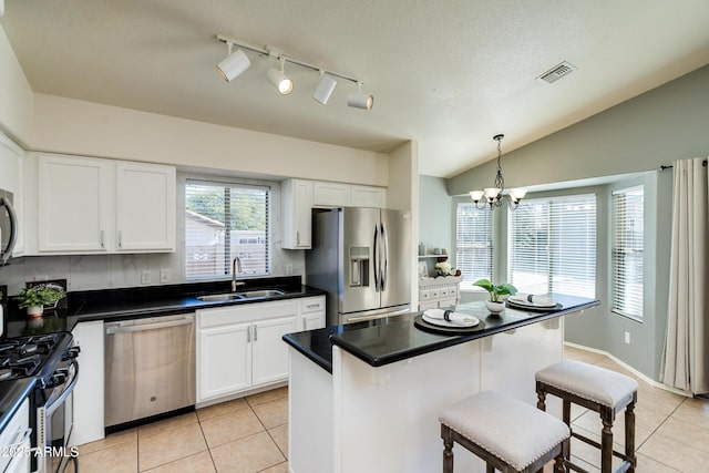 kitchen with stainless steel appliances, decorative light fixtures, sink, and white cabinets