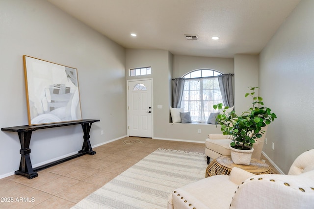 entrance foyer with lofted ceiling and light tile patterned floors