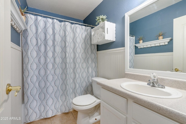 bathroom with tile patterned flooring, vanity, and toilet