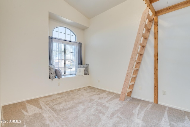 unfurnished room featuring vaulted ceiling and light carpet