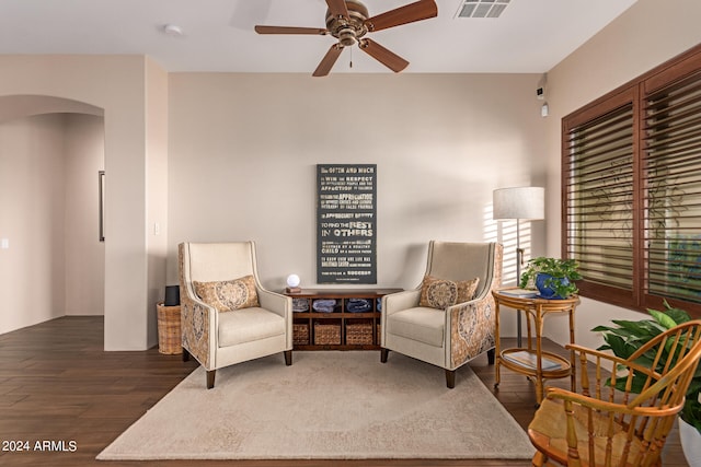 living area featuring arched walkways, wood finished floors, visible vents, and a ceiling fan