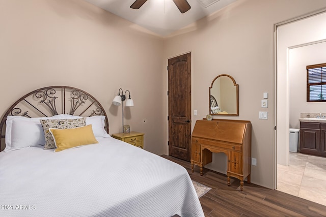 bedroom with wood-type flooring, ensuite bath, ceiling fan, and sink