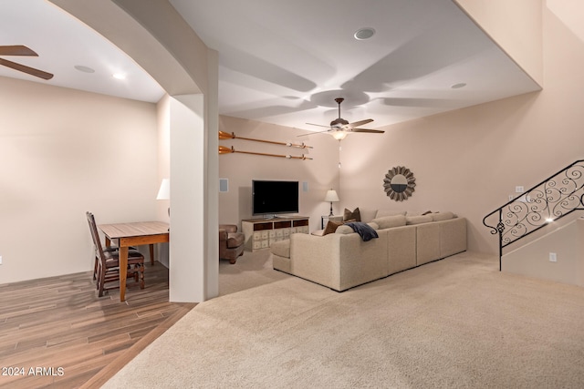 living room featuring stairs, a ceiling fan, and wood finished floors