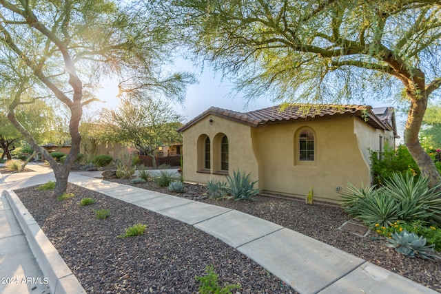 mediterranean / spanish house featuring a tiled roof and stucco siding