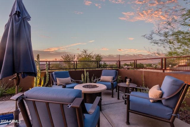 patio terrace at dusk featuring an outdoor living space with a fire pit