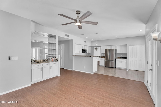 unfurnished living room with visible vents, ceiling fan, light wood-type flooring, recessed lighting, and a sink