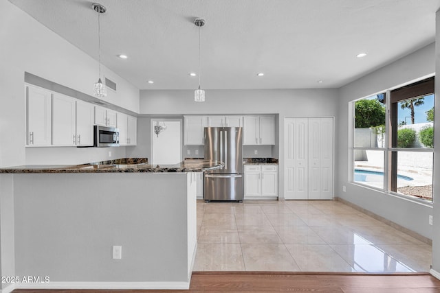 kitchen with visible vents, pendant lighting, white cabinetry, and stainless steel appliances