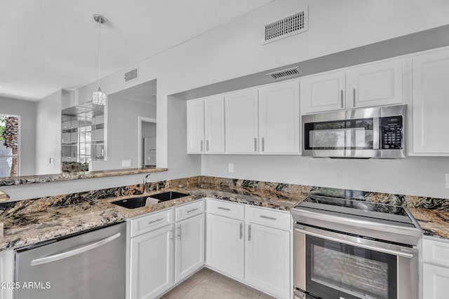 kitchen with visible vents, appliances with stainless steel finishes, a sink, stone countertops, and white cabinets