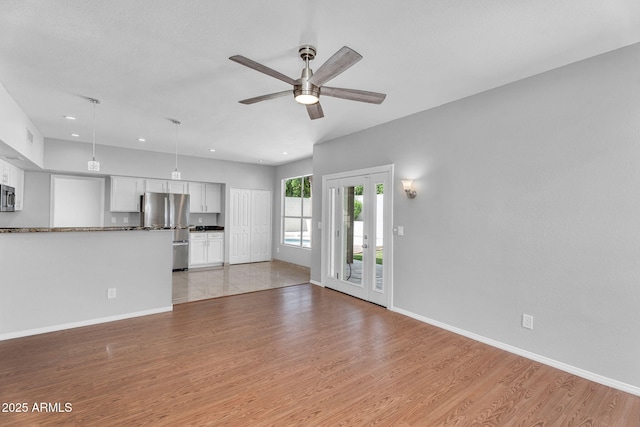 unfurnished living room featuring a ceiling fan, baseboards, recessed lighting, and light wood-type flooring