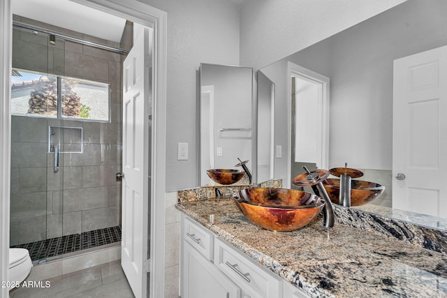 full bath featuring vanity, tile patterned floors, a stall shower, and toilet