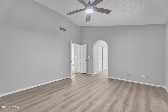 unfurnished room with a ceiling fan, a textured ceiling, visible vents, and lofted ceiling