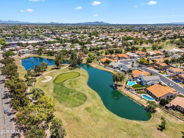 drone / aerial view with a water and mountain view, view of golf course, and a residential view