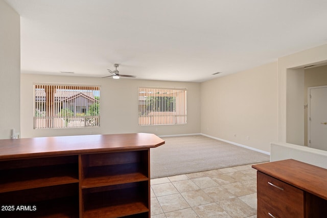 20007 N Siesta Rock Dr, Surprise, AZ 85374 - unfurnished dining area with light colored carpet, a ceiling fan, light tile patterned floors, and baseboards