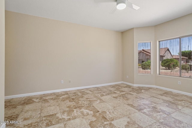 20007 N Siesta Rock Dr, Surprise, AZ 85374 - empty room featuring stone finish floors, a ceiling fan, and baseboards