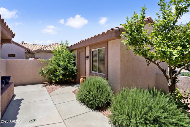 20007 N Siesta Rock Dr, Surprise, AZ 85374 - view of property exterior with fence, stucco siding, a tiled roof, and a patio area