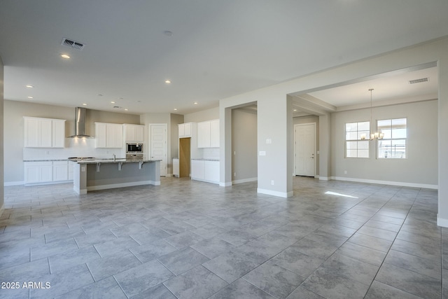 unfurnished living room with a notable chandelier