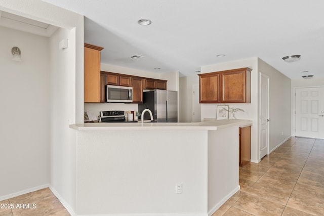 973 E Kelsi Ave, San Tan Valley, AZ 85140 - kitchen featuring stainless steel appliances, a peninsula, baseboards, and light countertops