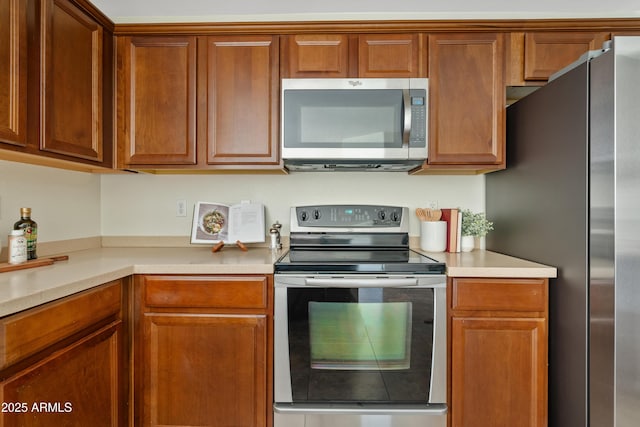 973 E Kelsi Ave, San Tan Valley, AZ 85140 - kitchen with stainless steel appliances, light countertops, and brown cabinetry