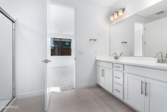 bathroom featuring tile patterned flooring, vanity, and an enclosed shower