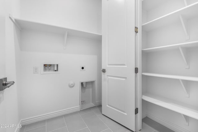 clothes washing area with hookup for an electric dryer, washer hookup, hookup for a gas dryer, and light tile patterned flooring