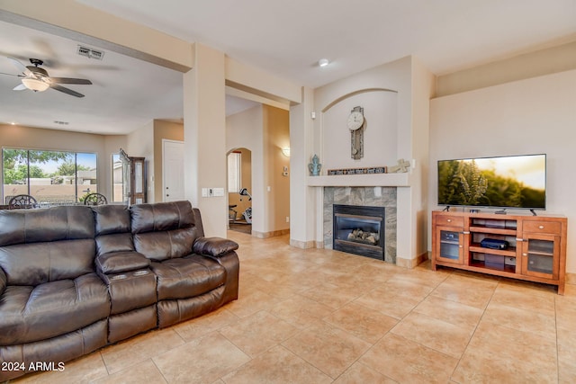 tiled living room featuring a premium fireplace and ceiling fan