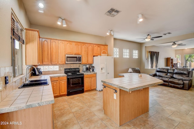 kitchen featuring tile countertops, white refrigerator with ice dispenser, backsplash, sink, and black range with electric cooktop