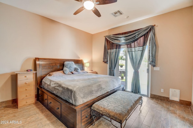 bedroom featuring access to exterior, light hardwood / wood-style floors, and ceiling fan