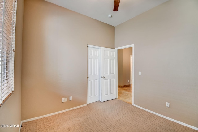 unfurnished bedroom with ceiling fan and light carpet