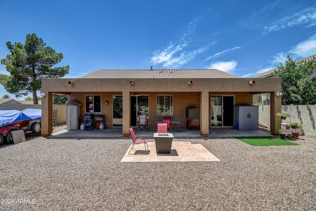 rear view of house featuring a fire pit and a patio area