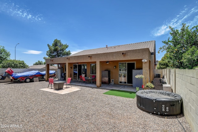 back of house with ceiling fan, a patio, and a fire pit