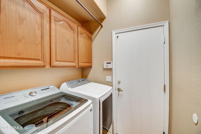 clothes washing area featuring cabinets and independent washer and dryer