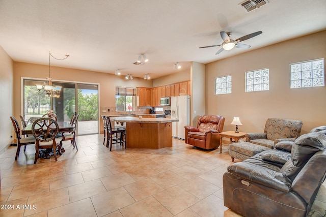 living room with ceiling fan with notable chandelier and light tile patterned flooring