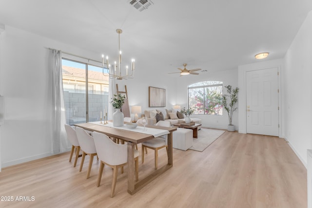 dining space featuring ceiling fan with notable chandelier and light hardwood / wood-style flooring