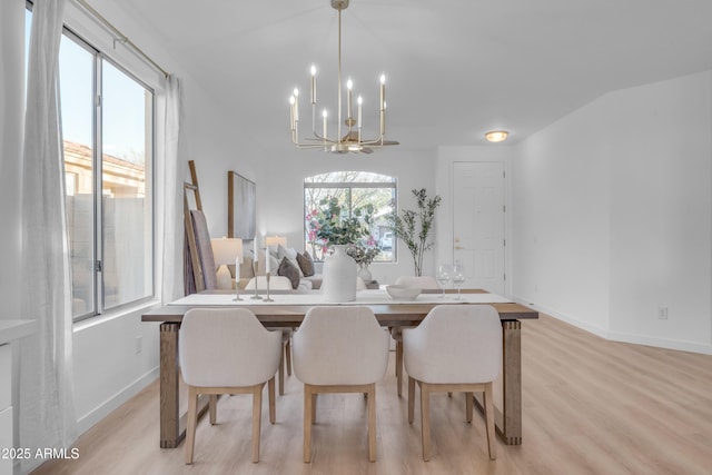 dining room with light hardwood / wood-style flooring and a notable chandelier