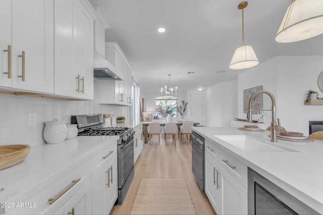 kitchen with white cabinets, hanging light fixtures, and stainless steel gas stove