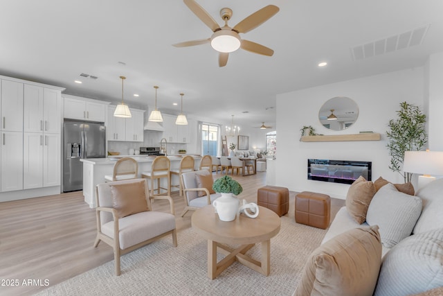 living room featuring ceiling fan and light hardwood / wood-style floors