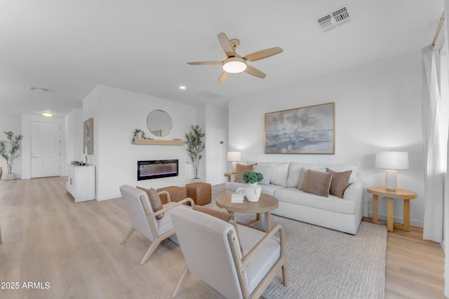 living room with ceiling fan and light hardwood / wood-style flooring