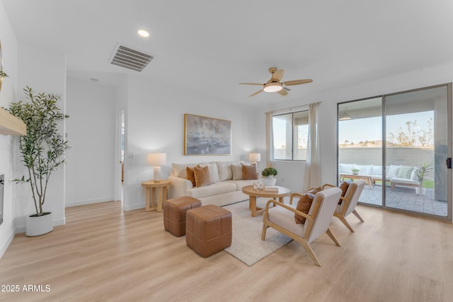 living room featuring light hardwood / wood-style floors and ceiling fan